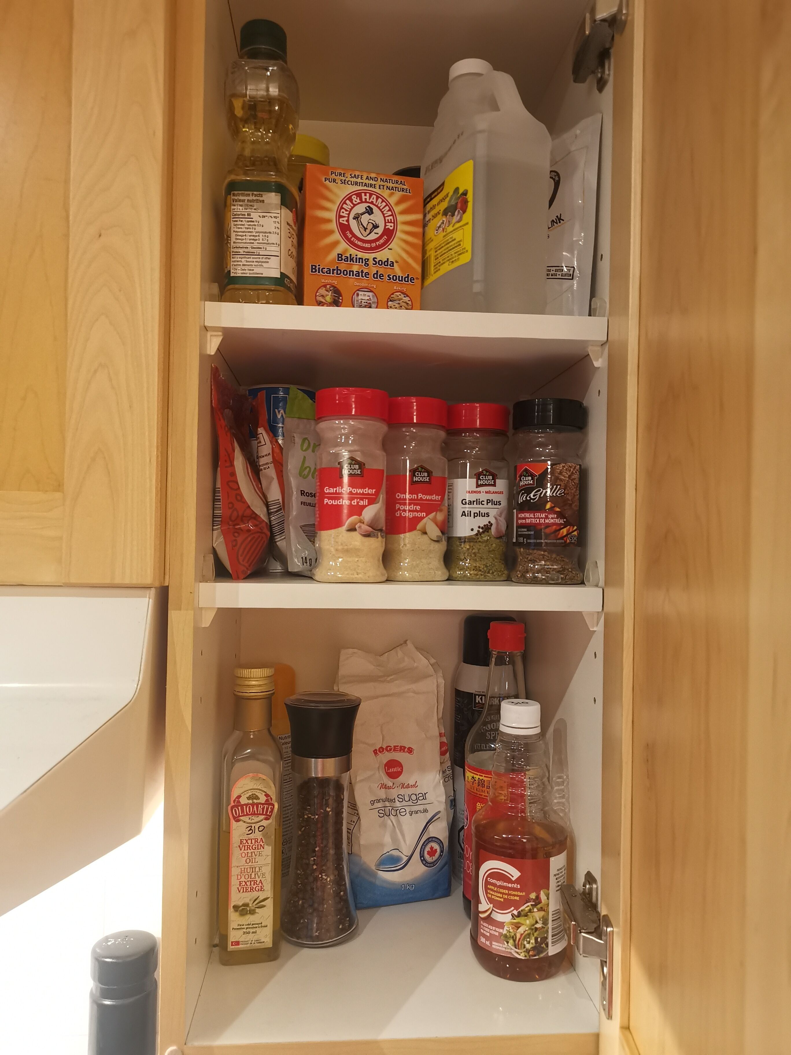 A kitchen pantry with various food items and condiments, including baking soda, sugar, and spices.