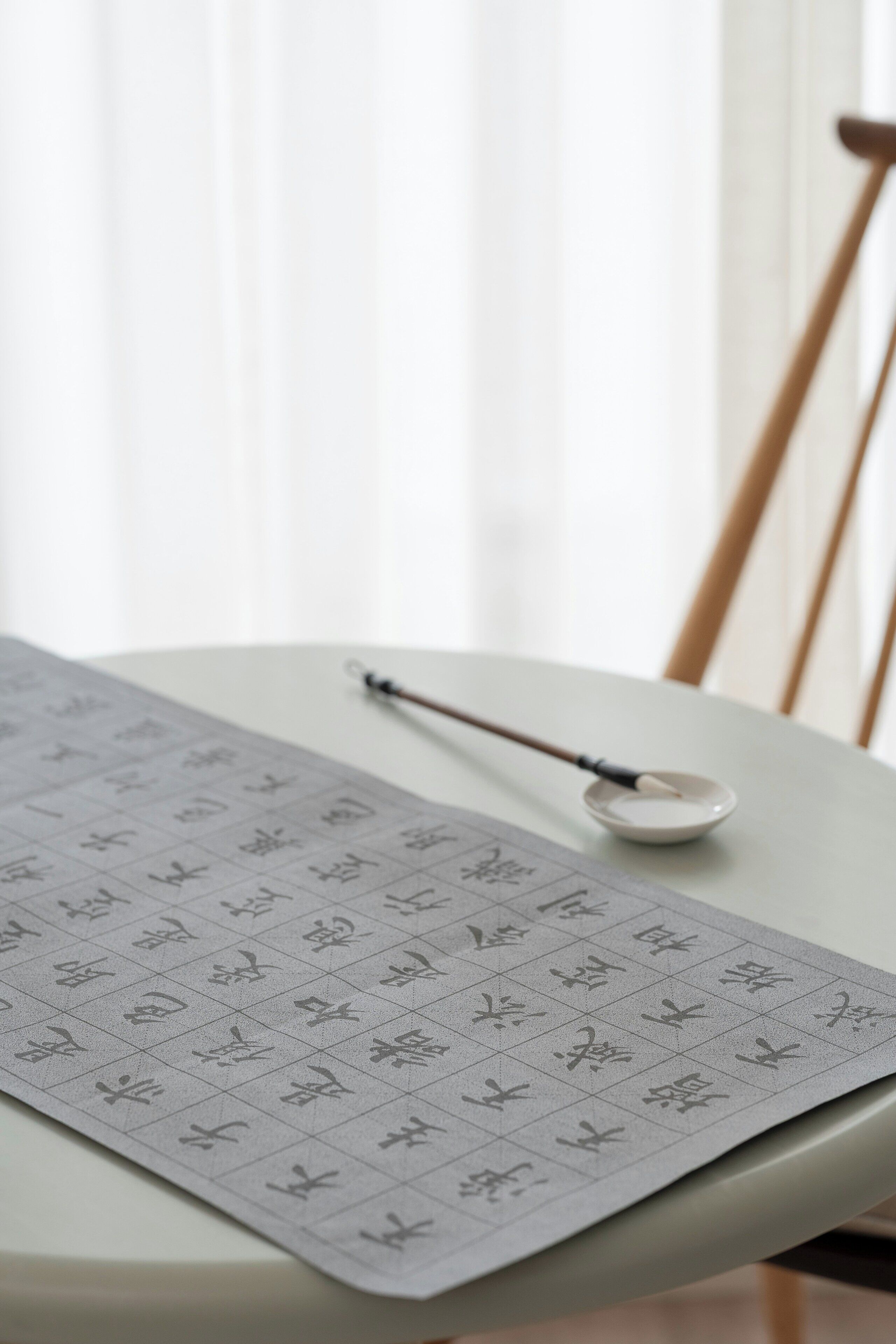 Une table avec un motif quadrillé, une cuillère et une chaise en arrière-plan.