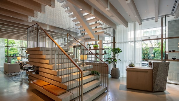 A modern interior with a staircase, wooden flooring, and a reception desk. - Zentis Osaka (Osaka)