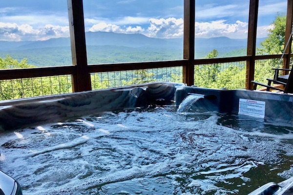 Enjoy mountain views from the large hot tub with multicolor lights and waterfall