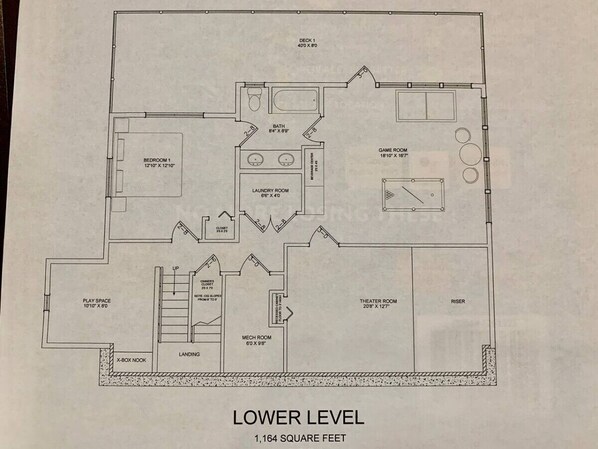 A floor plan of a building with a lower level measuring 1,164 square feet. It includes a bedroom, bathroom, laundry room, game room, play space, theater room, and a mechanic room.