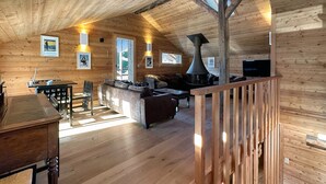 A wooden cabin interior with a dining area, living room, and a fireplace. - Les Granges de Sarreyer - 10 mns from Verbier - Sw (Sarreyer)