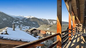 A wooden balcony with a view of snow-covered mountains and houses. - Les Granges de Sarreyer - 10 mns from Verbier - Sw (Sarreyer)