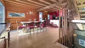 A wooden interior with a dining area, kitchen, and staircase. - Les Granges de Sarreyer - 10 mns from Verbier - Sw (Sarreyer)