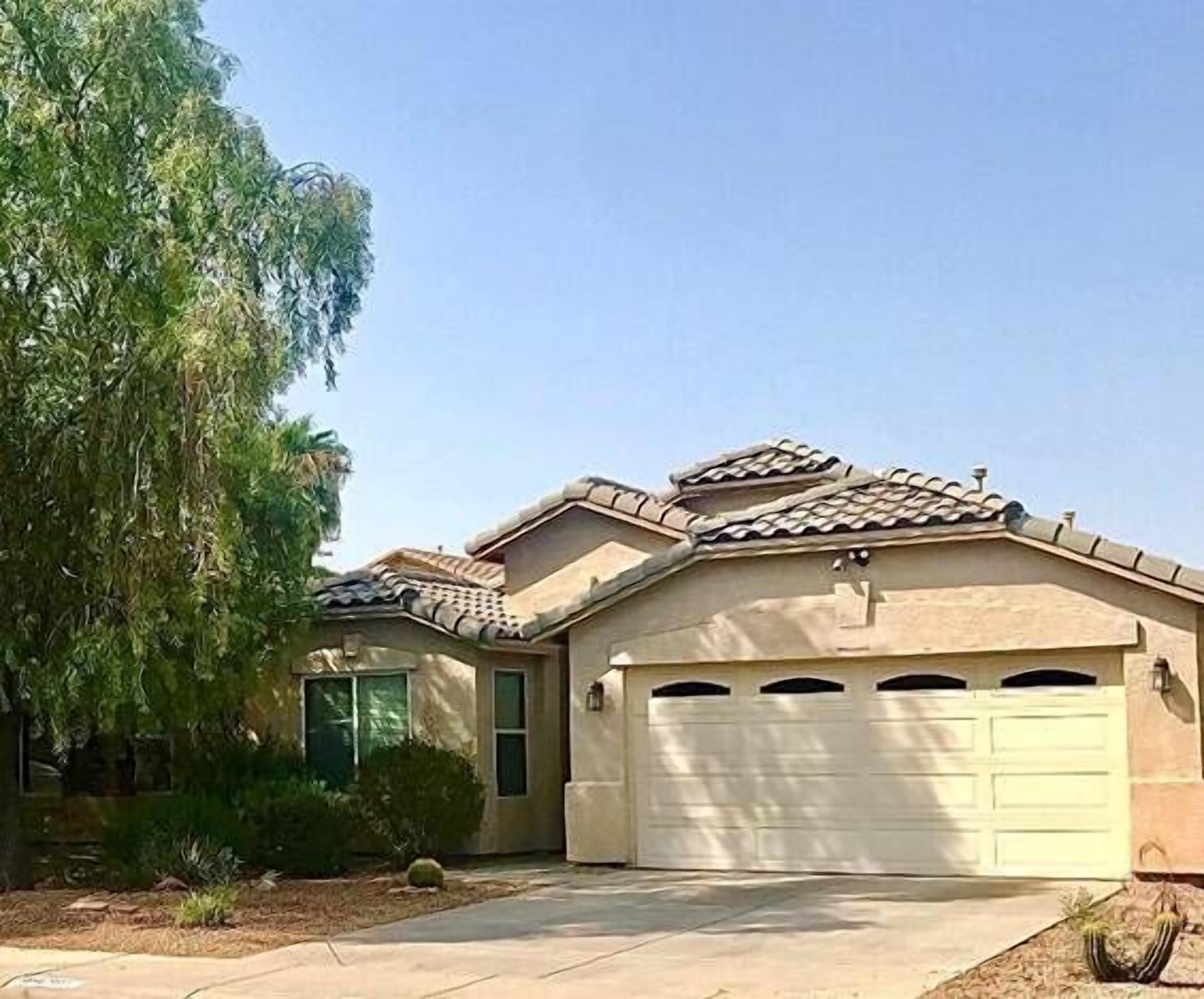 A residential house with a tiled roof, a garage, and a driveway.