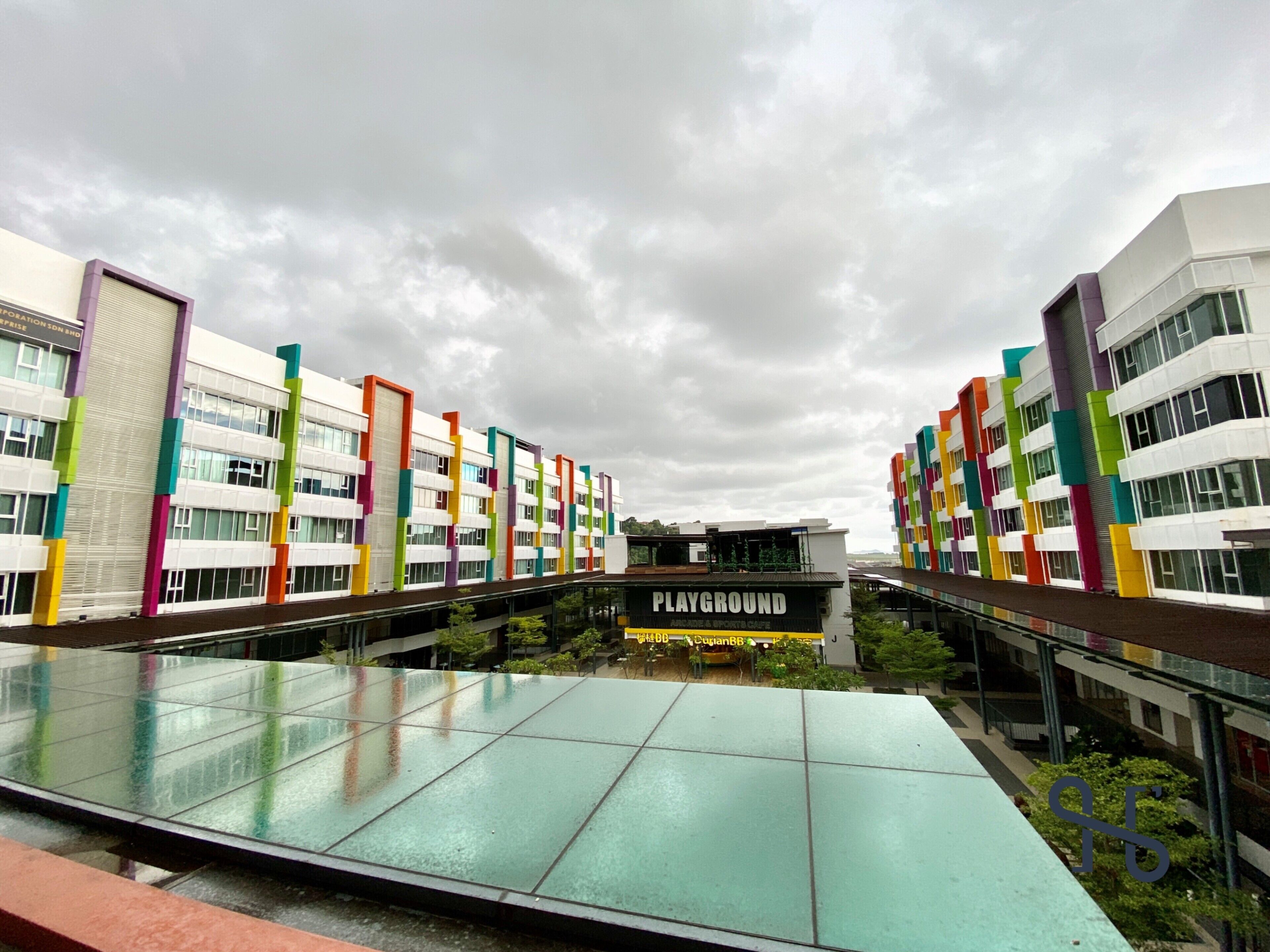 A modern building with colorful vertical accents and a glass atrium.