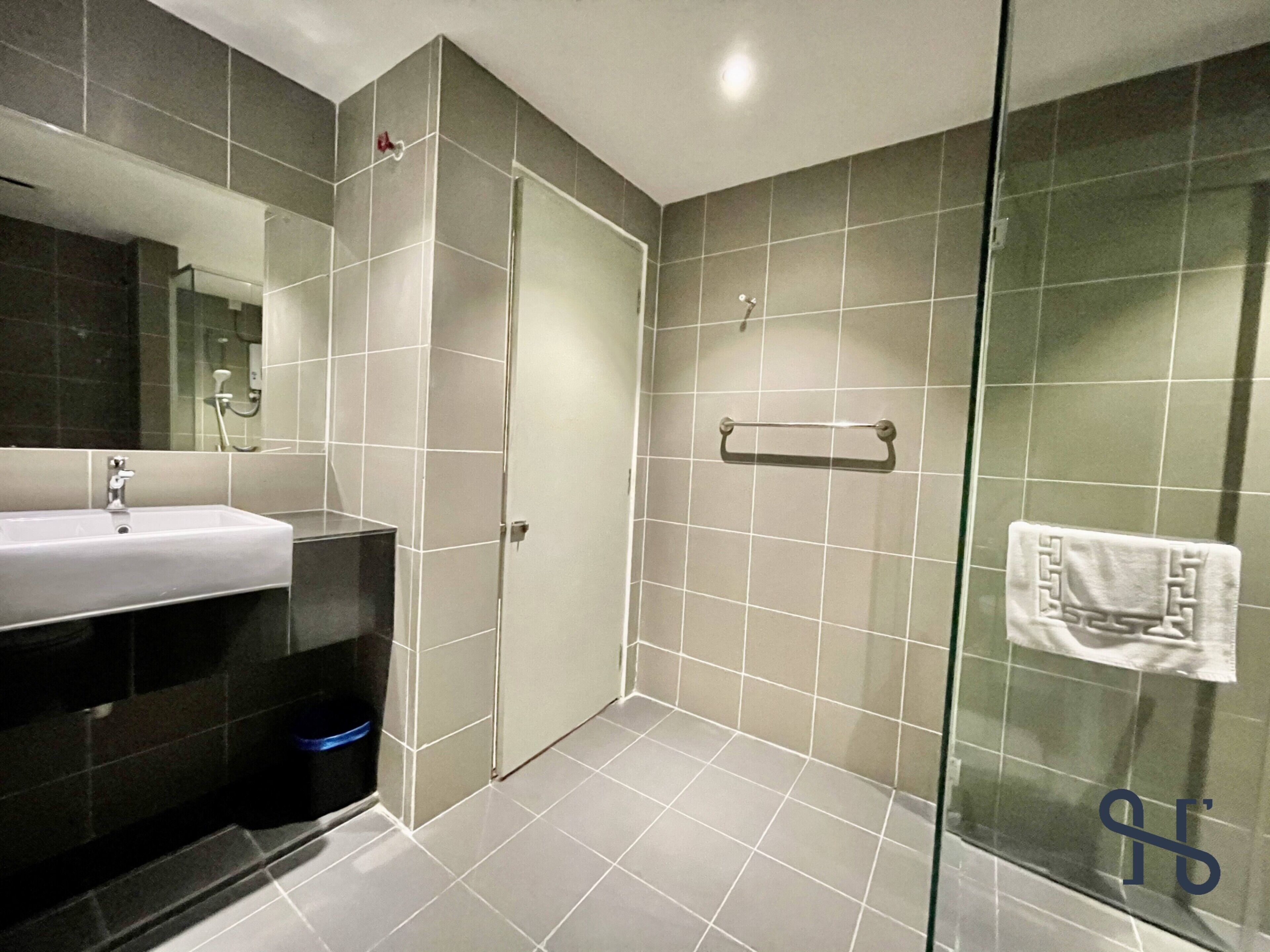 A modern bathroom with a glass shower enclosure, a sink, and a towel rack.