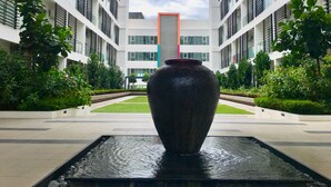 A modern building with a central water feature and a reflective surface.