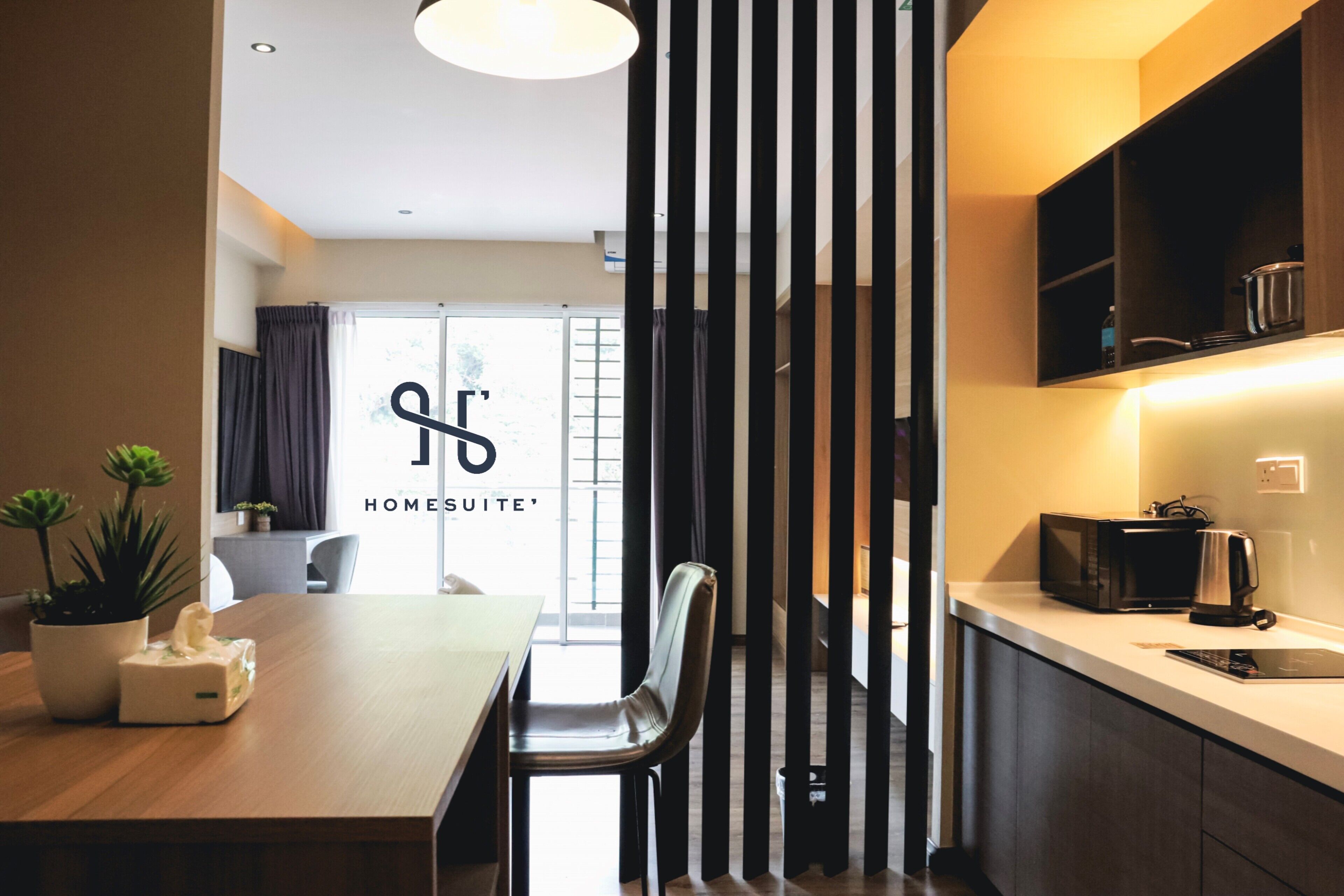 A modern kitchen with a dining area, featuring a wooden table, chairs, and a kitchen counter with appliances.