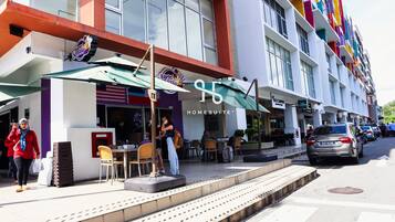 A hotel with outdoor seating and a storefront.