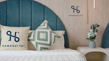 Restful retreat with a plush bed, geometric and simple pillows, and a stylish headboard.