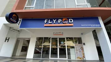 The exterior of Flypod Restaurant with a blue sign, large windows, and a visible entrance.