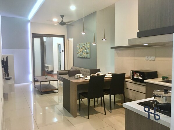 Una cocina moderna con comedor, que incluye microondas, estufa y mesa con sillas.