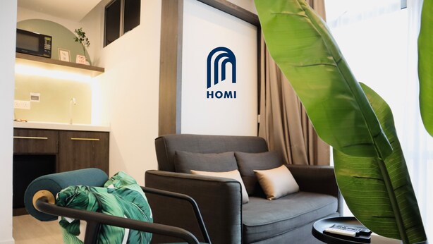 A modern living room with a sofa, a coffee table, and a green plant. - Homi Oasis 和逸绿洲 (Kota Kinabalu)