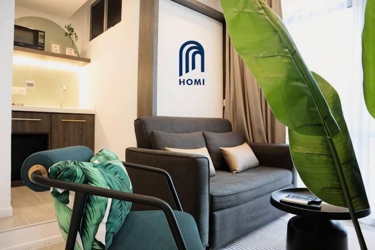 A modern living room with a grey sofa, a small table, and a green plant.