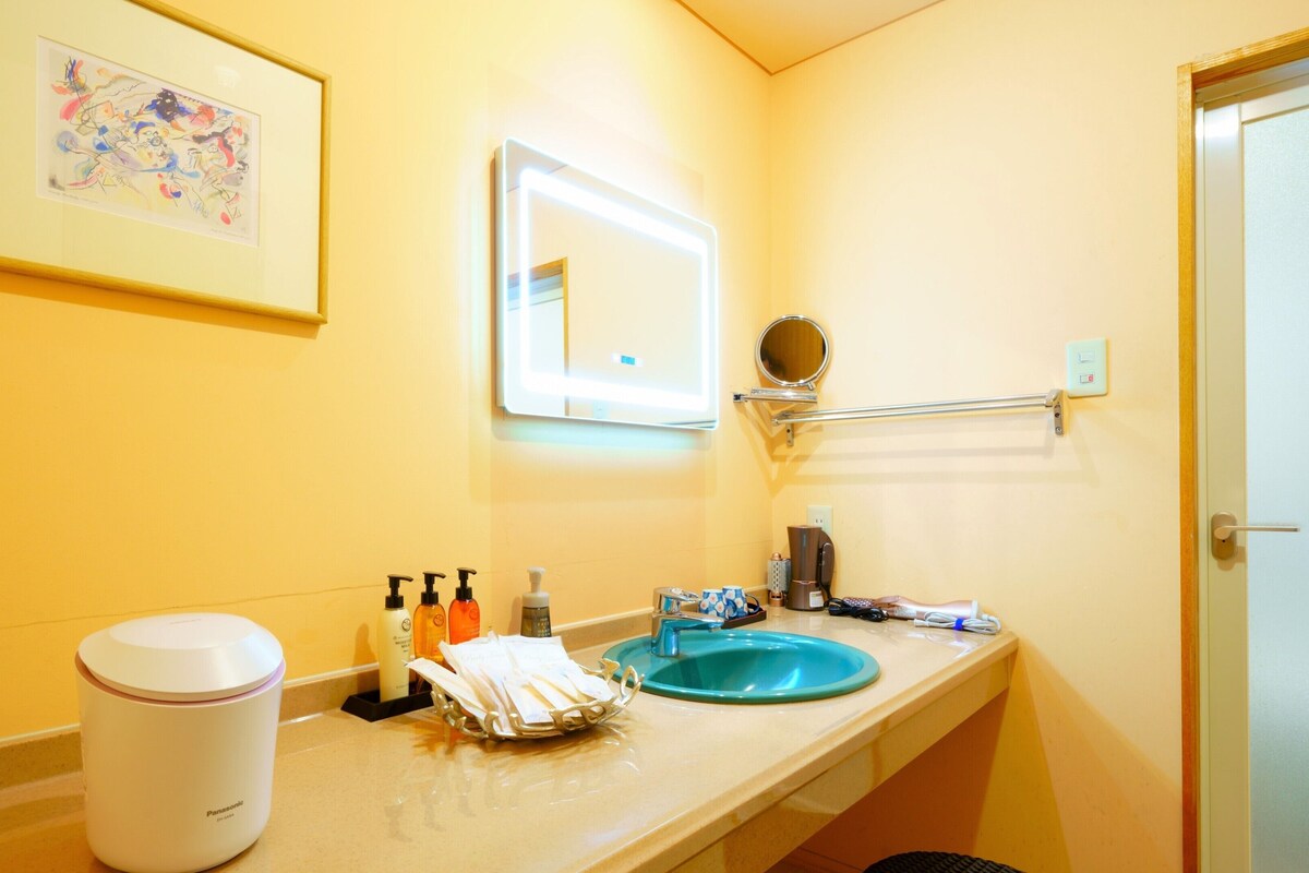 A bathroom with a sink, mirror, and toiletries.