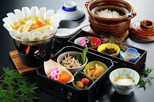 Una variedad de platos y tazones sobre una mesa, incluyendo arroz, fideos y otros alimentos.