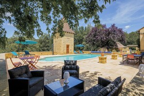 A poolside area with stone walls, outdoor furniture, and a stone building. - Renovated Périgordian holiday home (Nabirat)