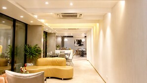 Ein modernes Interieur mit einer gebogenen Couch, einem Essbereich und Deckenstrahlern.