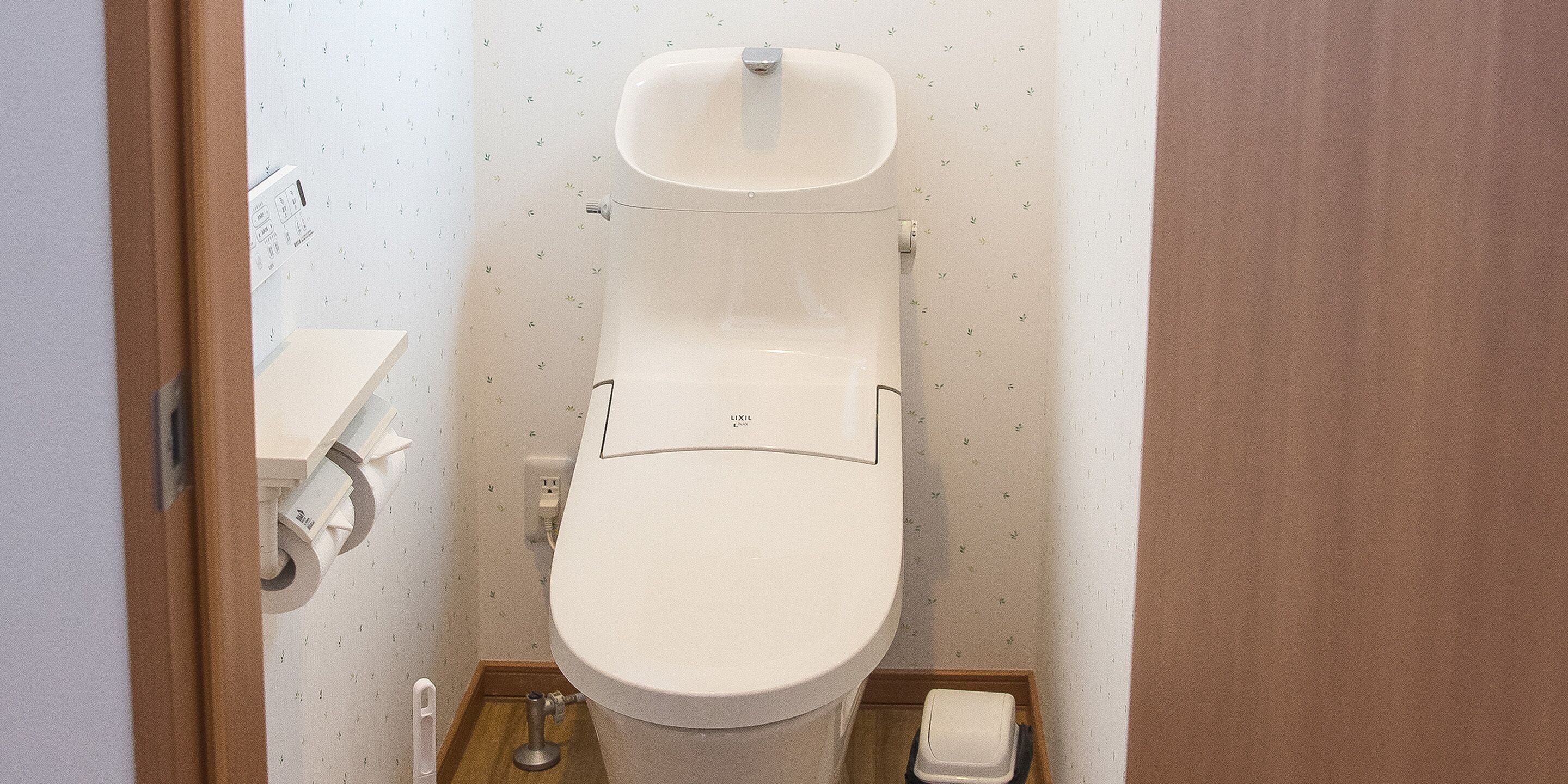 Un baño pequeño y funcional con inodoro, lavamanos y porta papel higiénico.