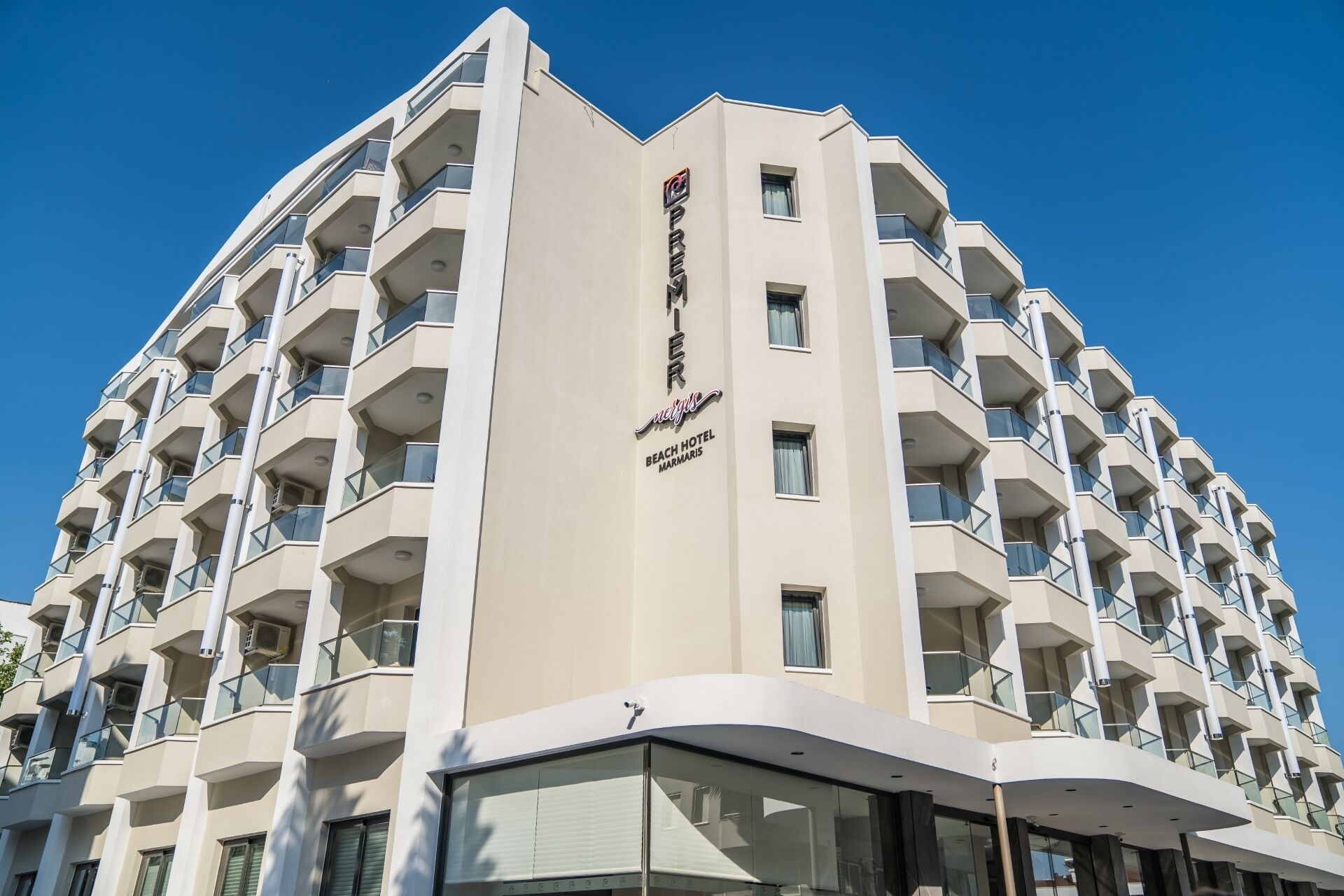 A modern hotel building with multiple balconies and a prominent sign indicating it is a beach hotel.