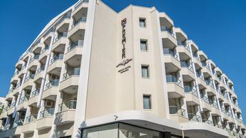 A modern hotel building with multiple balconies and a prominent sign indicating it is a beach hotel.