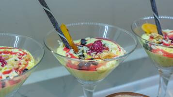 Three dessert glasses with fruit toppings and a spoon.