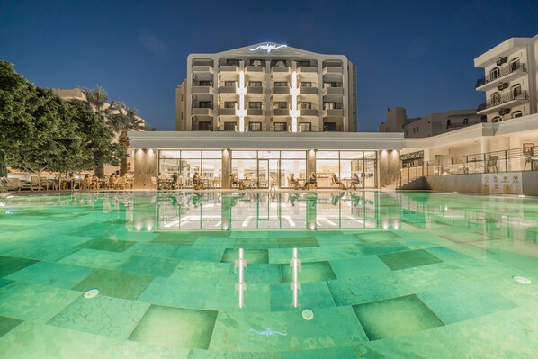 A hotel with a swimming pool, outdoor seating, and a large building with balconies. - Premier Nergis Beach (Marmaris)