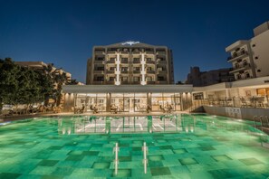 A hotel with a swimming pool, multiple floors, and a well-lit entrance. - Premier Nergis Beach (Marmaris)