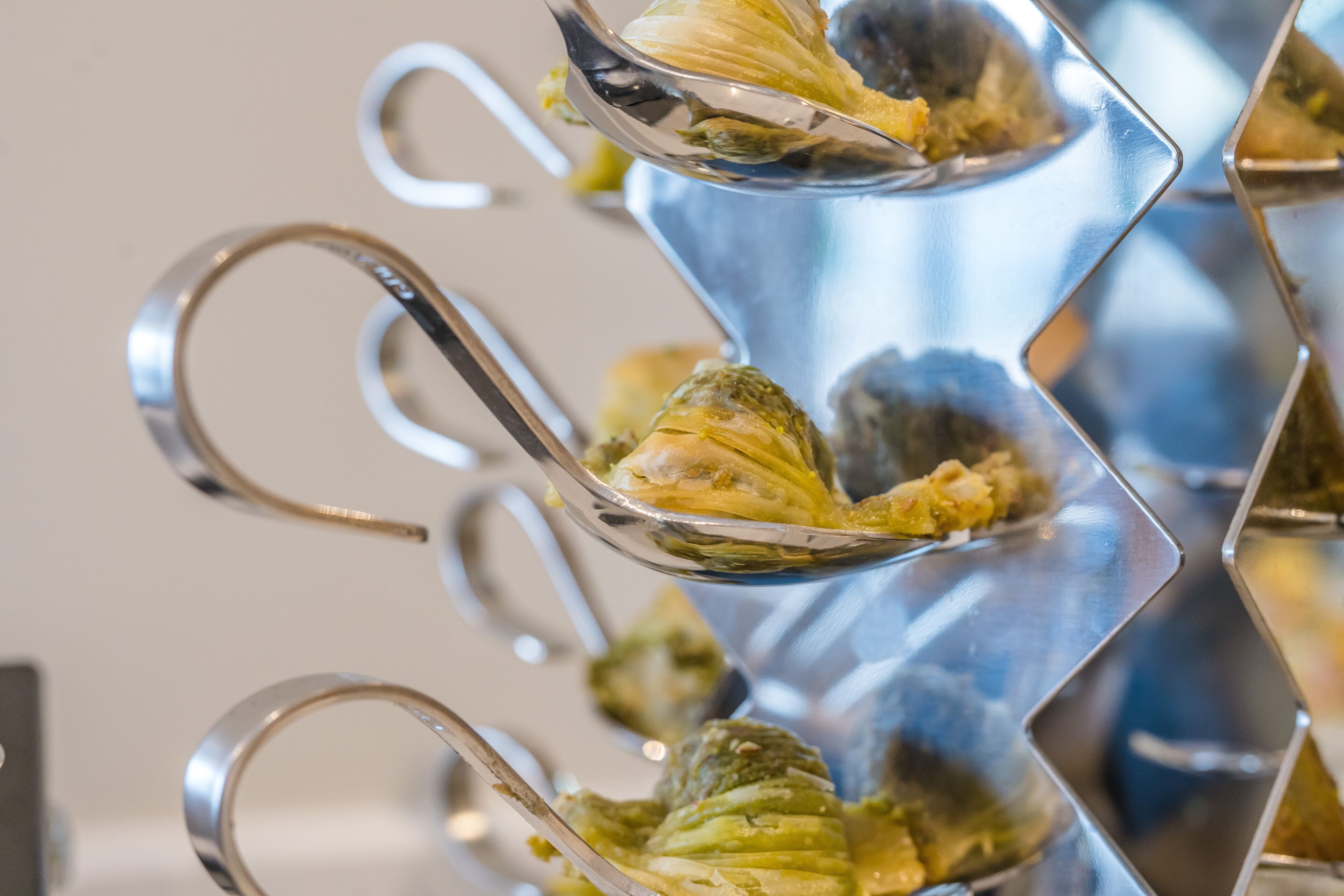 A close-up of a metallic, zigzag-shaped serving tray holding food items.