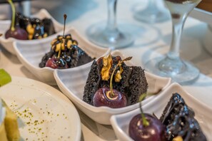 A dessert presentation with cherries and chocolate on white plates. - Premier Nergis Beach (Marmaris)