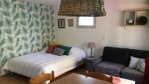Une pièce comprenant un lit, un canapé, une table à manger et une lampe.