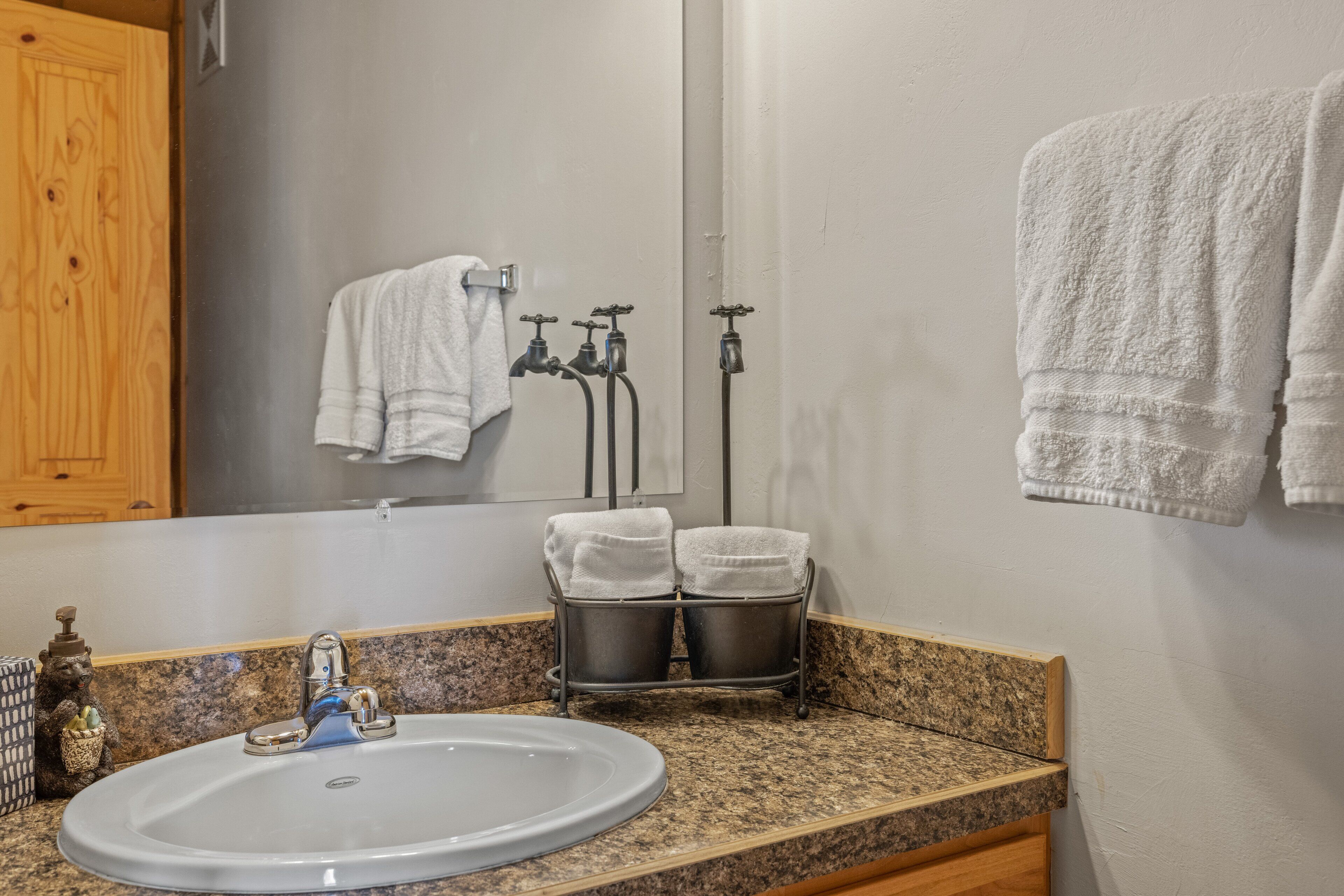Un baño con encimera de granito, un lavabo, un espejo, un perchero para toallas y un calentador de toallas.