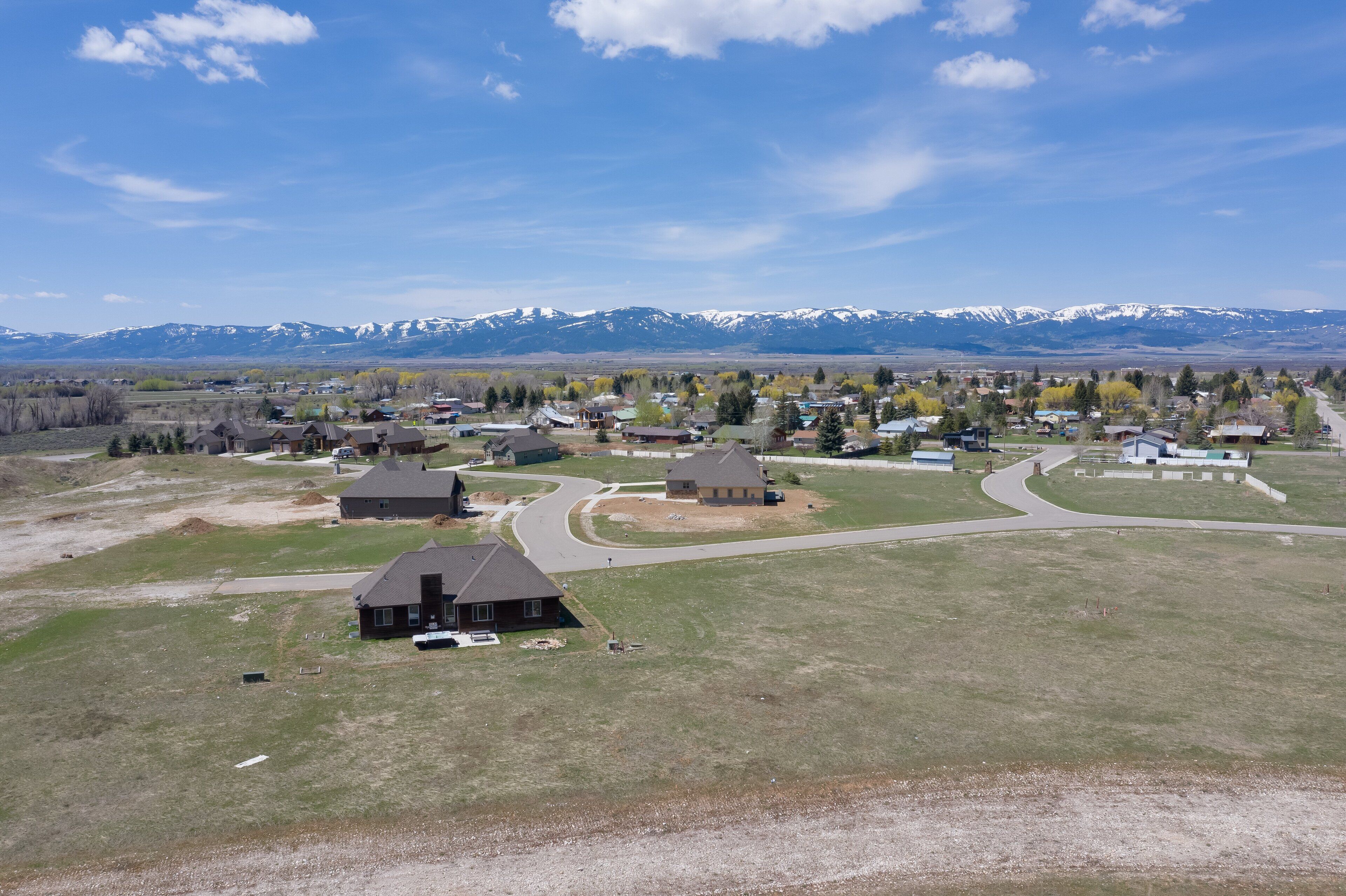 A residential area with houses, roads, and a mountain range in the background.