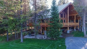 A log cabin with a wooden deck and a covered porch. - Lumberjack Lodge (Island Park)
