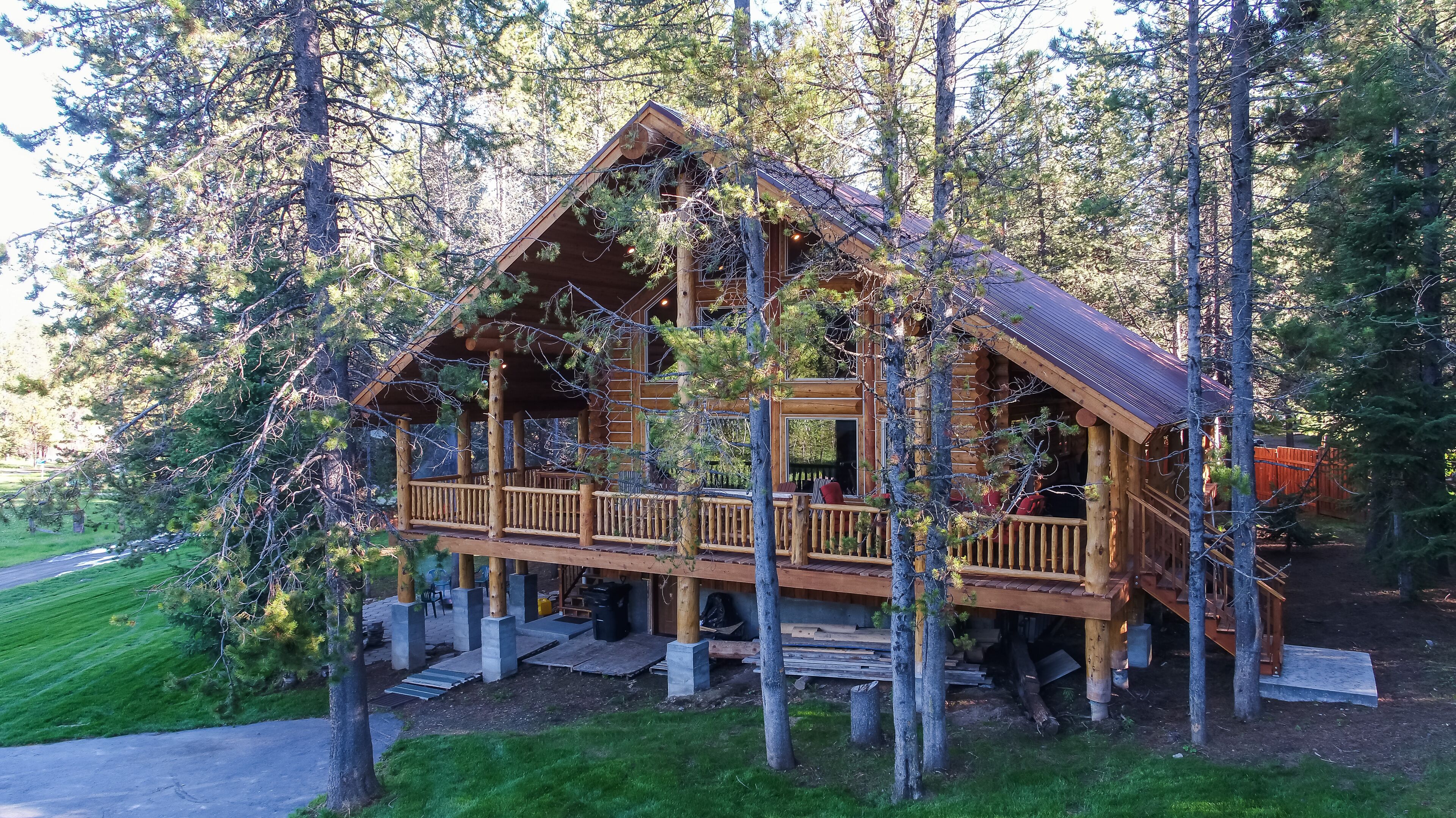 Una cabaña de madera con balcón, rodeada de árboles.