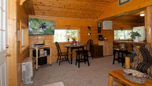 A cozy cabin interior with a dining area, kitchen, and seating space. - Remington Retreat (Island Park)