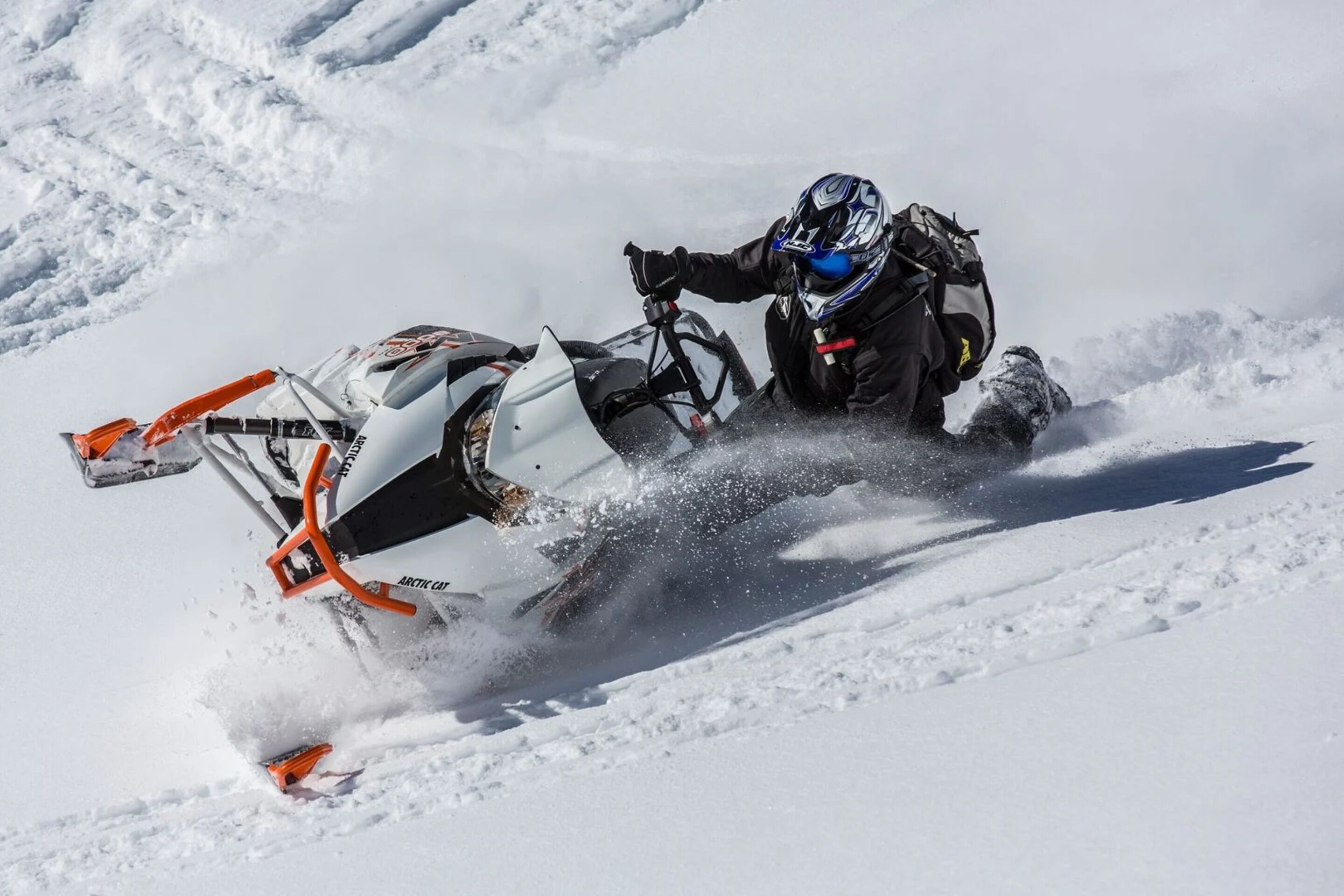 A person riding a snowmobile on a snowy surface.