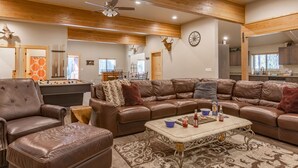 A spacious living room with a pool table, leather sofas, and a dining area. - Buck Buck Moose (Island Park)