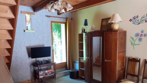 Una habitació amb un llit, una televisió, un armari i una finestra.