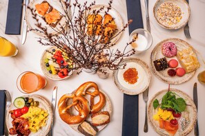 A breakfast buffet with various dishes including eggs, bacon, toast, and pastries.