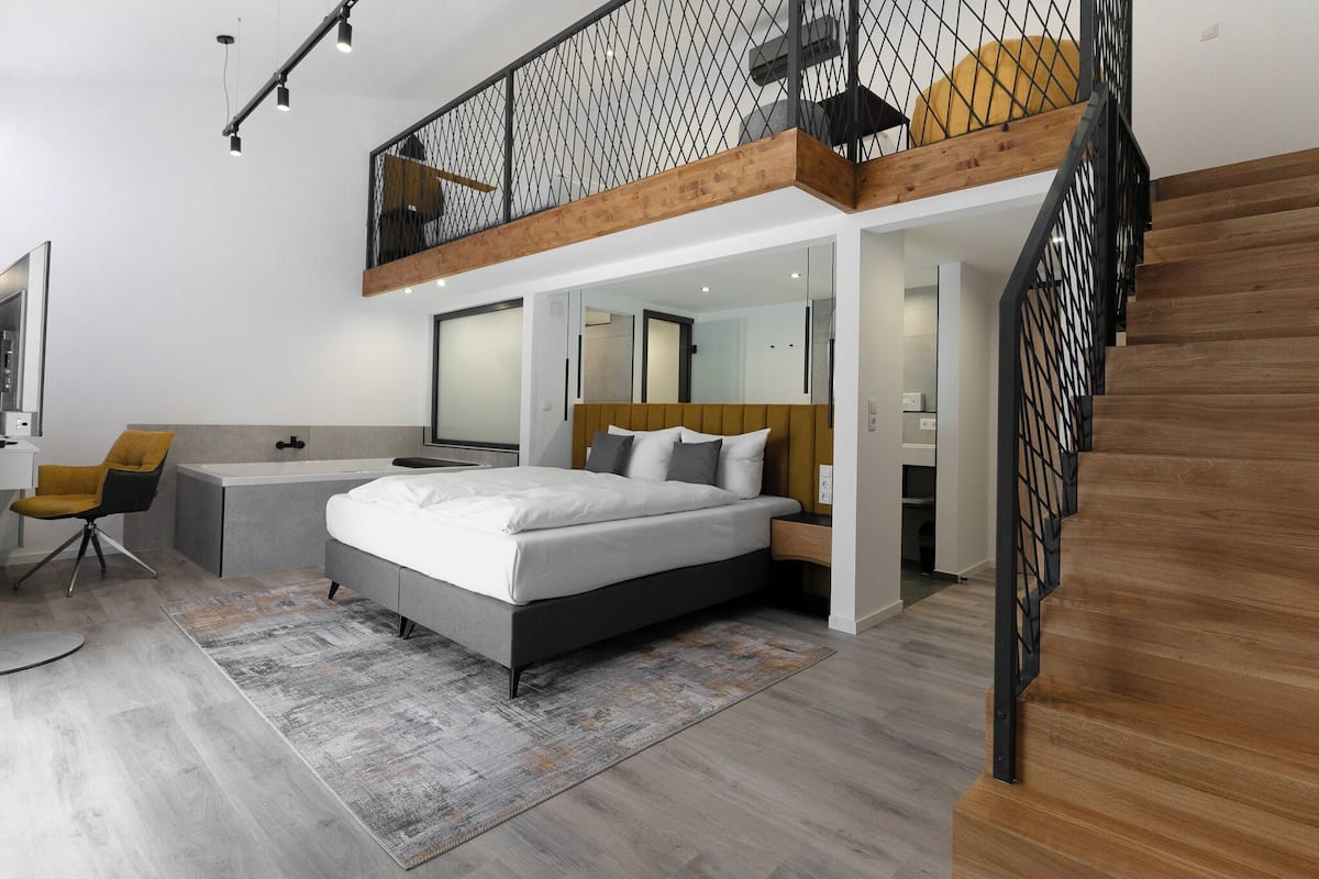 Suite junior, bañera de hidromasaje | 1 dormitorio, edredones de plumas, caja fuerte y escritorio