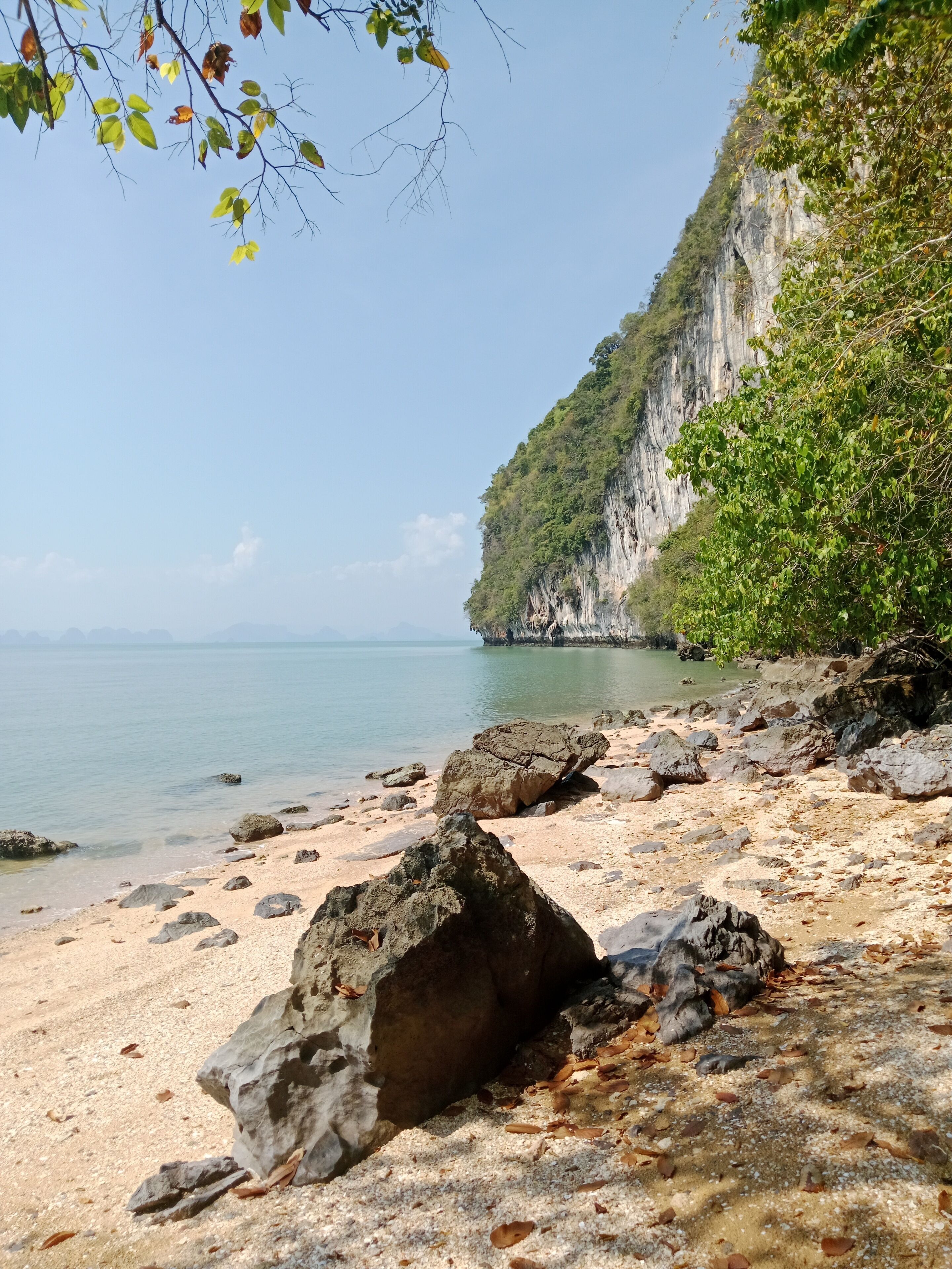A beach with rocky terrain and a cliff.