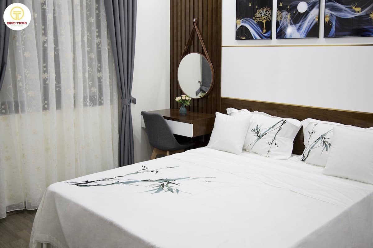 Een hotelkamer met een bed, een bureau, een stoel, een spiegel en kunst aan de muur.