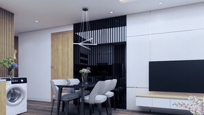 Een moderne keuken met een ingebouwde wasmachine, een eethoek met een tafel en stoelen, en een flatscreen televisie aan de muur.