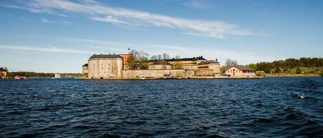 A historic building with a large tower, situated by a body of water.
