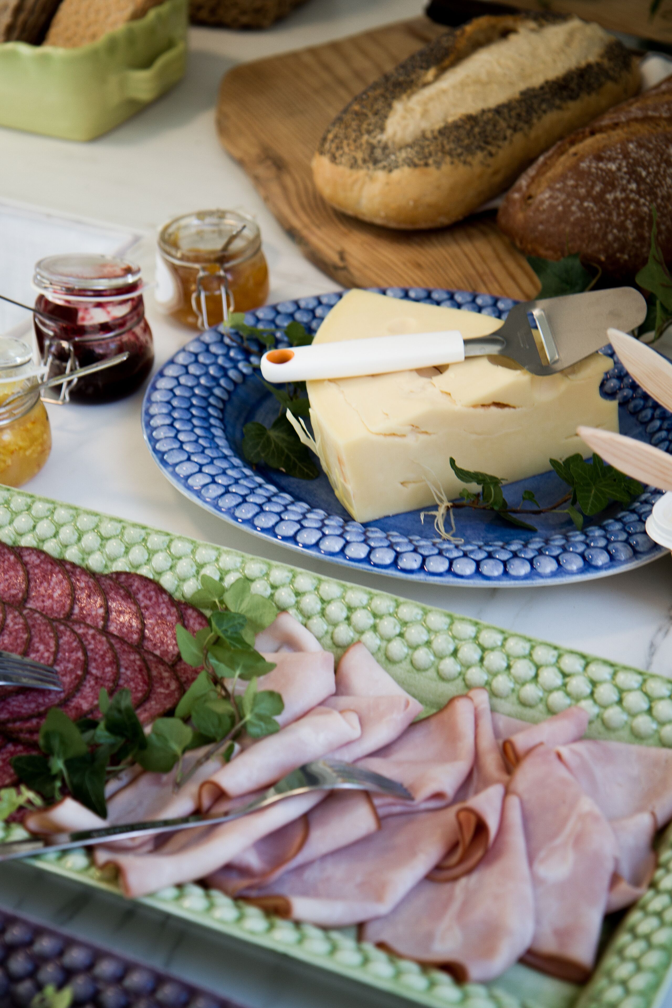 Ett bord med olika sorters mat, inklusive ost, bröd och skivad charkuterier.
