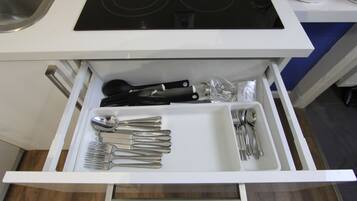 Un cajón de cocina con cubiertos ordenados, incluyendo tenedores, cuchillos y cucharas.