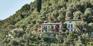 Une propriété située sur une colline, avec des bâtiments entourés d’une végétation luxuriante.