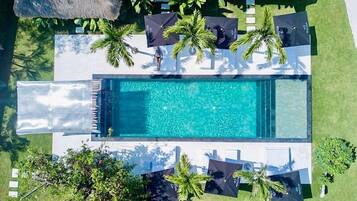 Una piscina al aire libre, tumbonas